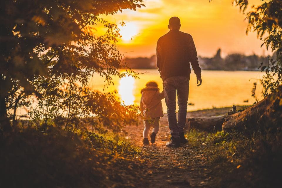 Father and child walking at sunset