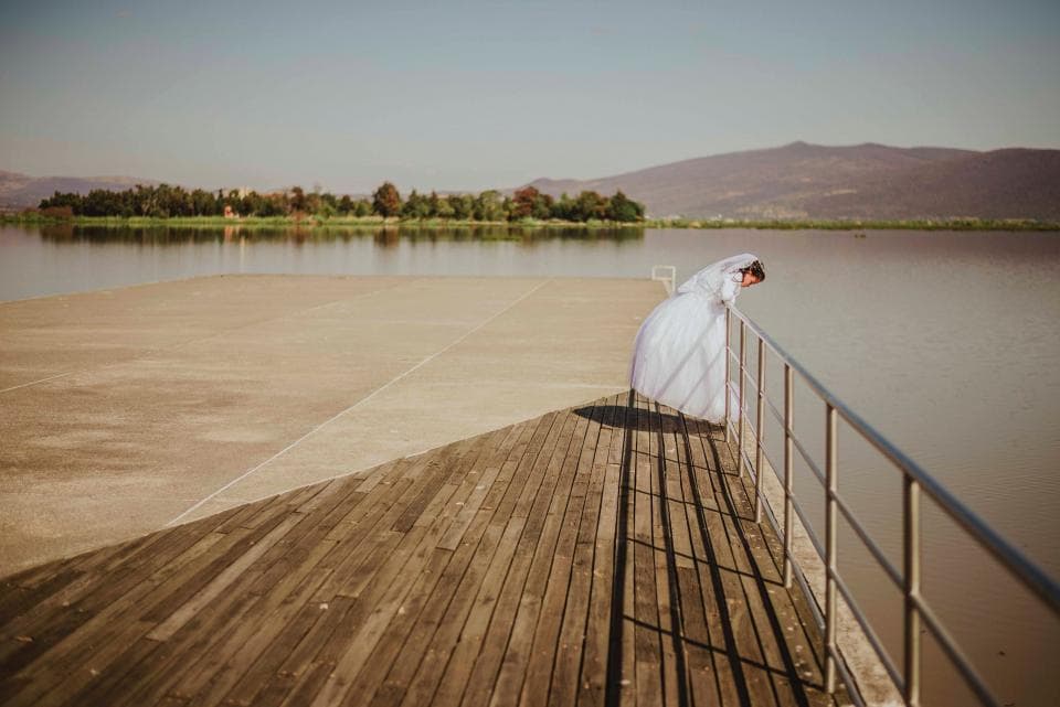 Bride standing on a lakeside pier