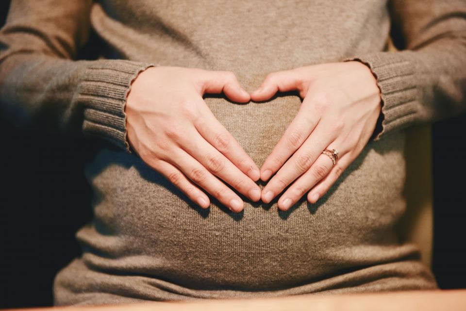 Hands making a heart over the bump